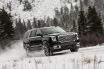 Picture of a driving 2018 GMC Yukon Denali in Onyx Black from a front right three-quarter perspective