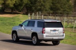 Picture of a driving 2018 GMC Yukon SLT in Quicksilver Metallic from a rear left three-quarter perspective
