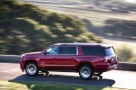 Picture of a driving 2018 GMC Yukon XL Denali in Red from a rear left three-quarter perspective