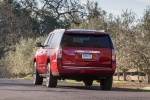 Picture of a driving 2018 GMC Yukon XL Denali in Red from a rear left perspective