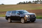 Picture of a driving 2018 GMC Yukon XL Denali in Iridium Metallic from a front right three-quarter perspective