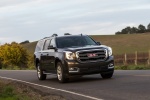 Picture of a driving 2018 GMC Yukon XL Denali in Iridium Metallic from a front right perspective