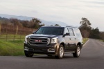 Picture of a driving 2018 GMC Yukon XL Denali in Iridium Metallic from a front left perspective