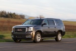 Picture of a driving 2018 GMC Yukon XL Denali in Iridium Metallic from a front left three-quarter perspective