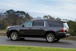 Picture of a driving 2018 GMC Yukon XL Denali in Iridium Metallic from a rear left three-quarter perspective