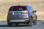 Picture of a driving 2015 Honda CR-V Touring in Modern Steel Metallic from a rear right perspective