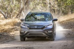 Picture of a driving 2015 Honda CR-V Touring in Modern Steel Metallic from a frontal perspective