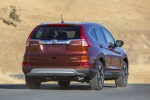 Picture of a driving 2015 Honda CR-V Touring AWD in Basque Red Pearl II from a rear right perspective