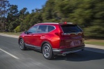 Picture of a driving 2017 Honda CR-V Touring AWD in Molten Lava Pearl from a rear left three-quarter perspective