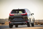 Picture of a driving 2017 Honda CR-V Touring AWD in Crystal Black Pearl from a rear perspective