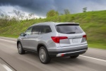 Picture of a driving 2016 Honda Pilot AWD in Lunar Silver Metallic from a rear left three-quarter perspective