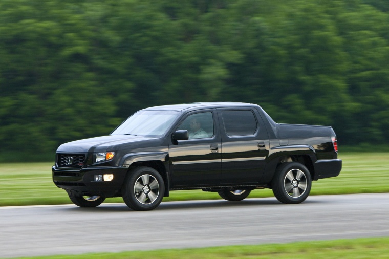 Picture of a driving 2013 Honda Ridgeline in Crystal Black Pearl from a front left three-quarter perspective