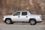 Picture of a driving 2013 Honda Ridgeline in Alabaster Silver Metallic from a side perspective