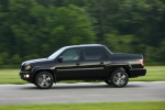 Picture of a driving 2013 Honda Ridgeline in Crystal Black Pearl from a side perspective