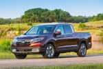 Picture of a driving 2017 Honda Ridgeline AWD in Deep Scarlet Pearl from a front left three-quarter perspective