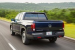 Picture of a driving 2017 Honda Ridgeline AWD in Obsidian Blue Pearl from a rear left perspective