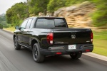 Picture of a driving 2017 Honda Ridgeline Black Edition AWD in Crystal Black Pearl from a rear left perspective