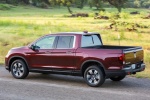 Picture of a driving 2018 Honda Ridgeline AWD in Deep Scarlet Pearl from a rear left three-quarter perspective