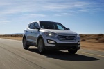Picture of a driving 2014 Hyundai Santa Fe Sport in Moonstone Silver from a front right perspective