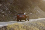 Picture of a driving 2014 Hyundai Santa Fe Sport in Serrano Red from a rear right perspective
