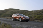 Picture of a driving 2014 Hyundai Santa Fe Sport in Serrano Red from a front right three-quarter perspective