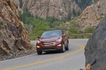 Picture of a driving 2014 Hyundai Santa Fe Sport in Serrano Red from a front left perspective