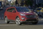 Picture of a driving 2015 Hyundai Santa Fe in Regal Red Pearl from a front right perspective