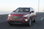 Picture of a driving 2016 Hyundai Santa Fe in Regal Red Pearl from a front left perspective