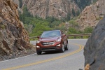 Picture of a driving 2016 Hyundai Santa Fe Sport in Serrano Red from a front left perspective