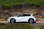 Picture of a driving 2018 Infiniti QX30 in Majestic White from a side perspective
