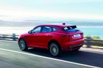Picture of a driving 2018 Jaguar E-Pace P300 R-Dynamic AWD in Firenze Red Metallic from a rear left three-quarter perspective