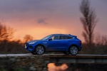 Picture of a driving 2018 Jaguar E-Pace P300 R-Dynamic AWD in Caesium Blue Metallic from a side perspective