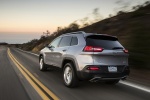 Picture of a driving 2017 Jeep Cherokee Limited 4WD in Billet Silver Metallic Clearcoat from a rear left three-quarter perspective