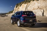 Picture of a driving 2017 Jeep Cherokee Limited 4WD from a rear left perspective
