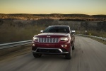 Picture of a driving 2014 Jeep Grand Cherokee Summit 4WD in Deep Cherry Red Crystal Pearlcoat from a front left perspective