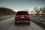 Picture of a driving 2014 Jeep Grand Cherokee Summit 4WD in Deep Cherry Red Crystal Pearlcoat from a rear perspective