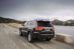 Picture of a driving 2014 Jeep Grand Cherokee Limited Diesel 4WD in Granite Crystal Metallic Clearcoat from a rear left three-quarter perspective