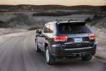 Picture of a driving 2014 Jeep Grand Cherokee Limited Diesel 4WD in Granite Crystal Metallic Clearcoat from a rear left perspective