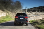 Picture of a driving 2014 Jeep Grand Cherokee Limited Diesel 4WD in Granite Crystal Metallic Clearcoat from a rear perspective