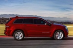 Picture of a driving 2014 Jeep Grand Cherokee SRT 4WD in Redline 2 Coat Pearl from a side perspective