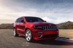 Picture of a driving 2014 Jeep Grand Cherokee SRT 4WD in Redline 2 Coat Pearl from a front right perspective