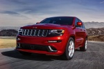 Picture of a driving 2014 Jeep Grand Cherokee SRT 4WD in Redline 2 Coat Pearl from a front left perspective