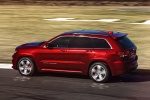 Picture of a driving 2014 Jeep Grand Cherokee SRT 4WD in Redline 2 Coat Pearl from a rear left three-quarter perspective
