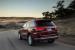 Picture of a driving 2015 Jeep Grand Cherokee Summit 4WD in Deep Cherry Red Crystal Pearlcoat from a rear left three-quarter perspective