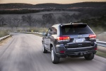 Picture of a driving 2015 Jeep Grand Cherokee Limited Diesel 4WD in Granite Crystal Metallic Clearcoat from a rear left perspective