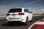 Picture of a driving 2015 Jeep Grand Cherokee SRT 4WD in Bright White Clear Coat from a rear right perspective