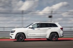 Picture of a driving 2016 Jeep Grand Cherokee SRT 4WD in Bright White Clear Coat from a side perspective