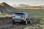Picture of a driving 2015 Land Rover Discovery Sport HSE Luxury in Scotia Gray Metallic from a rear right perspective