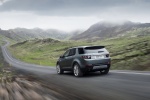 Picture of a driving 2015 Land Rover Discovery Sport HSE Luxury in Scotia Gray Metallic from a rear left perspective
