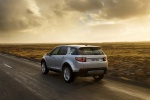 Picture of a driving 2015 Land Rover Discovery Sport HSE Luxury in Indus Silver Metallic from a rear left perspective